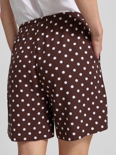 Vrouwenmodel draagt korte broek model 'Lavisco' van FREE/QUENT, viscosemix met linnen en rechte pasvorm, bruine stof met witte stippen, tunnelkoord. Ganzkörperaanzicht achteraan, bandwijdte maat S 42 cm, binnenbeenlengte maat S 16 cm.