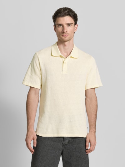 Männermodel trägt Regular Fit Poloshirt mit Knopfleiste Modell 'Gabriel' von Wood Wood, Reine Baumwolle, Herren, Ganzkörperansicht von vorne. Rückenlänge bei Größe M: 70 cm. Helle, leicht gelbliche Farbe, dezente Struktur.