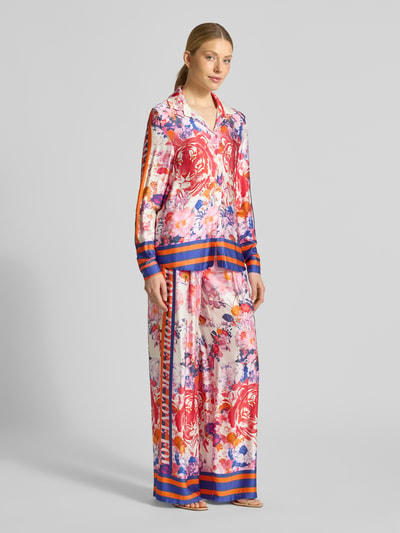 Frauenmodel trägt Wide Leg Hose aus Viskose Modell 'wild Flower' von miss goodlife, bunte florale Muster, Ganzkörperansicht von vorne.