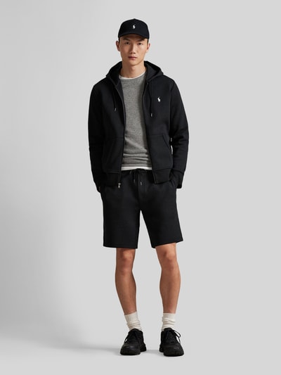Männermodel trägt schwarze Regular Fit Sweatshorts aus Baumwoll-Mix von Polo Ralph Lauren mit elastischem Bund und Logo-Stitching, Ganzkörperansicht von vorne.