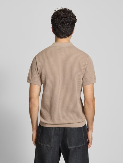 Męski model nosi Modern Fit Poloshirt mit kurzer Knopfleiste Modell 'JESS' od Jack & Jones, bawełniany miks, półprzezroczysta faktura, kołnierzyk polo, beżowy kolor, widok całej sylwetki z tyłu.