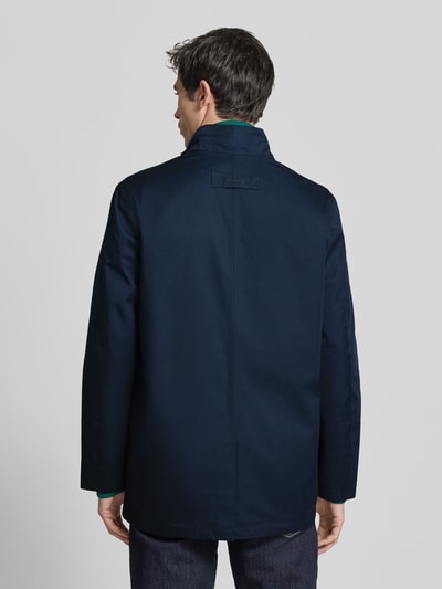 Mannelijk model draagt Regular Fit Parka met katoenmix van Barbour, effen donkerblauw, opstaande kraag, loopsplit, lange mouw, waterafstotend, ademend, rits- en klepzakken, labelopschrift. Ganzkörperansicht Rückansicht.