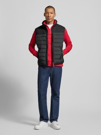 Mannelijk model draagt Regular Fit bodywarmer uit waterdicht materiaal van Tom Tailor, look: effen, regular fit, opstaande kraag, ritssluiting, functie: waterdicht, ademend, waterafstotend, materiaalverwerking: gerecycled materiaal, Ganzkörperansicht van voren.