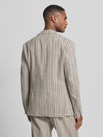 Męski model nosi Slim Fit 2-Knopf-Sakko mit Pattentaschen Modell 'CIDATA' von CINQUE, beżowy materiał z wełną, krój slim fit, długość pleców w rozmiarze 50: 76 cm, szerokość ramion w rozmiarze 50: 42 cm, długość rękawa w rozmiarze 50: 64 cm, pionowe pasy, widok całej sylwetki z tyłu.