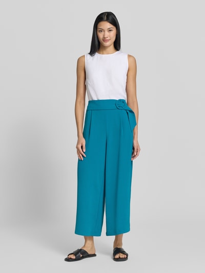 Frauenmodel trägt Culotte mit französischen Eingrifftaschen von zero in Türkis, weiter Loose Fit, weißes Top, Ganzkörperansicht von vorne.
