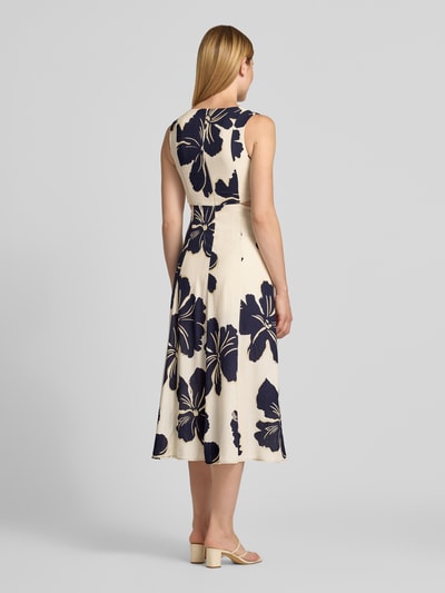 Frauenmodel trägt Midikleid aus Viskose-Mix Modell 'Olimpio' von MANGO mit floralem Print, taillierte Passform, Ganzkörperansicht Rückansicht.
