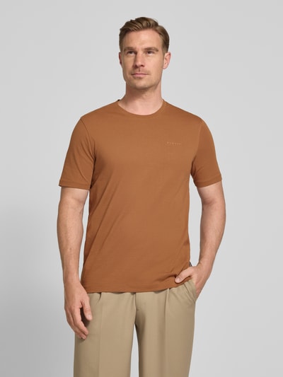 Männermodel trägt T-Shirt mit Label-Detail von bugatti in Braun, reine Baumwolle, gerader Schnitt, Rundhals, Nahaufnahme Oberkörper.