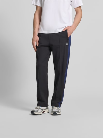 Männermodel trägt Sweatpants mit Logo-Stitching von Kenzo in Schwarz mit Ziernähten und elastischem Bund aus Reine Baumwolle, Straight Fit, Ganzkörperansicht von vorne.