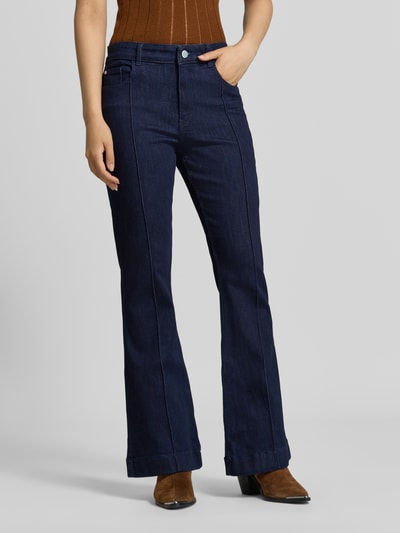Kobiece modelka nosi Flared Fit Jeans aus Baumwoll-Mix von Christian Berg Woman, ciemnoniebieskie, rozkloszowany krój, 5 kieszeni, zapięcie na guzik i zamek błyskawiczny, mieszanka bawełny, szerokość w rozmiarze 36/32: 39 cm, długość wewnętrzna nogawki: 78 cm, zdjęcie całej sylwetki z przodu.