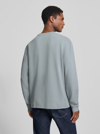 Männermodel trägt Regular Fit Langarmshirt aus Baumwoll-Mix Modell 'WE-TEMPEST' von BOSS Orange, Optik: Unifarben, Feinripp, Ganzkörperansicht Rückansicht.