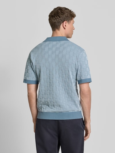 Męski model nosi Relaxed Fit Poloshirt aus reiner Baumwolle Modell 'MILAS' od SELECTED HOMME, efekt: wielokolorowy, wzór w kratkę, fason: krój relaxed fit, dekolt w serek, krótki rękaw, dzianina, bawełna, widok całej sylwetki z tyłu.