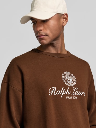 Männermodel trägt Regular Fit Sweatshirt aus Baumwoll-Mix von Polo Ralph Lauren in Braun, Label-Print, Optik: Unifarben, Nahaufnahme Oberkörper.