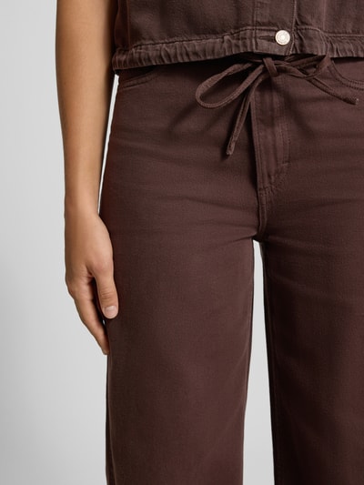 Frauenmodel trägt Wide & Loose Fit Jeans aus Baumwoll-Lyocell-Mix von Marc O'Polo, dunkelbraun, glatte Textur, Nahaufnahme Oberkörper, Damen Wide & Loose Fit Jeans von Marc O'Polo DENIM.