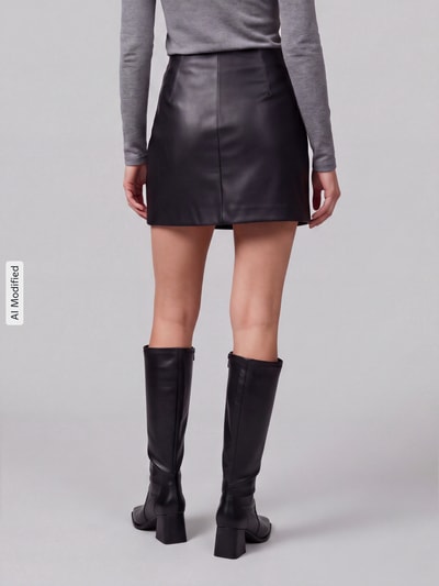 Frauenmodel trägt schwarzen Regular Fit Mini-Rock in Leder-Optik Modell 'NIELLA' von ONLY, Damen Mini-Rock, Ganzkörperansicht Rückansicht, KI-modifiziertes Bild.