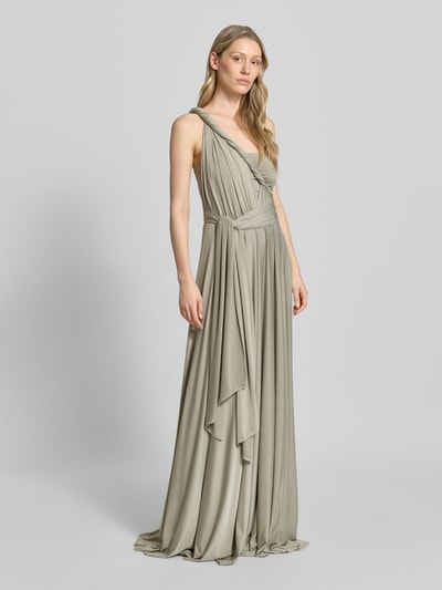 Frauenmodel trägt Maxikleid mit tiefem V-Ausschnitt von Rose Avenue, taillierter Schnitt, Rückseite gekreuzte Träger, Taillenband, Rückenlänge bei Größe S 135 cm, fließender Stoff in hellem Beige, Ganzkörperansicht von vorne.