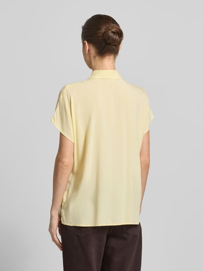Frauenmodel trägt Regular Fit Bluse aus Viskose von Christian Berg Woman in hellem Gelb, Hemdblusenkragen, Knopfleiste, Rückansicht, Rückenlänge 64 cm, Ärmellänge 15 cm, schlichte glatte Textur, Ganzkörperansicht Rückansicht.