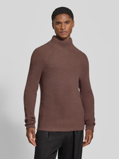 Männermodel trägt Regular Fit Strickpullover mit elastischen Abschlüssen von DRYKORN, Material-Mix mit Woll-Anteil, braun gerippt, Ganzkörperansicht von vorne.