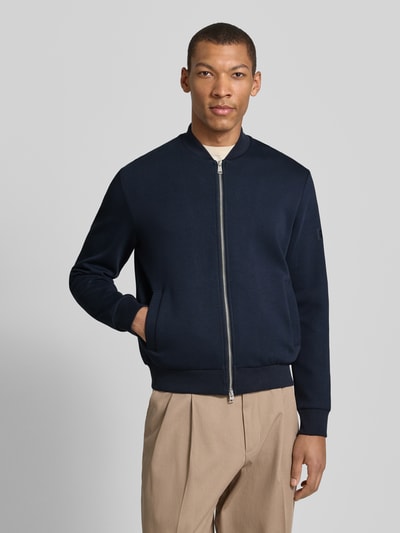 Männermodel trägt Regular Fit Bomberjacke aus Baumwoll-Mix von Marc O'Polo, Optik: Unifarben, College-Kragen, Ganzkörperansicht von vorne.