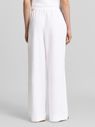 Frauenmodel trägt Hose mit Stitchings Modell 'Heifa' von Neo Noir aus reiner Baumwolle in Weiß, Wide Leg, elastischer Bund, Ganzkörperansicht Rückansicht.