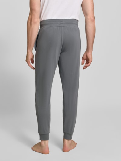 Männermodel trägt Regular Fit Sweathose aus Baumwoll-Mix Modell 'Laze Pants CW' von HUGO in Grau, Herren Sweathose, Ganzkörperansicht Rückansicht.