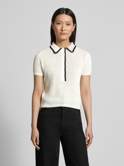 Frauenmodel trägt Regular Fit Strick-Shirt aus reiner Baumwolle Modell 'SLYSA' von HUGO mit Strukturmuster, kurzarm, unifarben, Kontraststreifen, Logo-Stitching, gerippte Abschlüsse, Ganzkörperansicht von vorne.