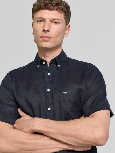Männermodel trägt Regular Fit Leinenhemd mit Button-Down-Kragen von Fynch-Hatton, dunkles Reines Leinen, Brusttasche, Nahaufnahme Oberkörper. Rückenlänge 75 cm, Schulterbreite 44 cm, Ärmellänge 27 cm bei Größe M.