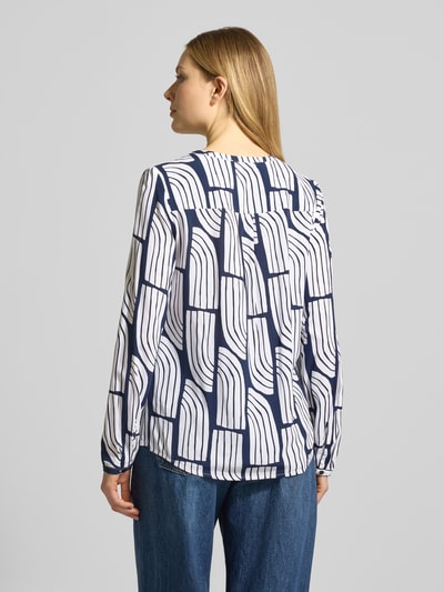 Frauenmodel trägt Wellen-Print Schlupfbluse aus Viskose von Christian Berg Woman, Regular-Fit, Rückenlänge 66 cm, Ärmellänge 63 cm, Ganzkörperansicht Rückansicht.