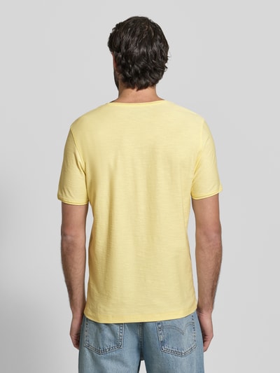 Męski model nosi T-Shirt mit geripptem Rundhalsausschnitt von MCNEAL, krój regular fit, długość tyłu w rozmiarze M: 65 cm, jasny żółty, gładka tekstura, widok całej sylwetki od tyłu.