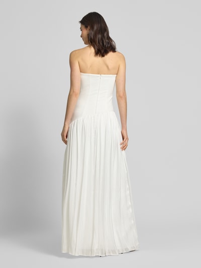 Frauenmodel trägt Slim Fit Brautkleid in Falten-Optik von Unique, schulterfrei, leichte A-Linie, blickdichter Unterrock, Ganzkörperansicht Rückansicht.