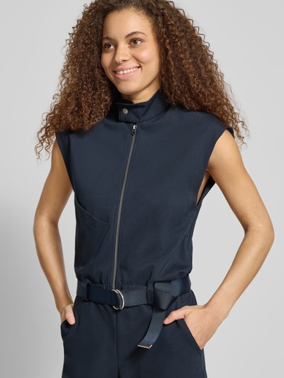 Vrouwenmodel draagt Jumpsuit aus Viskose-Mix mit Reißverschluss und Gürtel van G-Star Raw in donkerblauw, regular fit, met stretch, opstaande kraag, ritssluiting en riem, borstwijdte 46 cm, totale lengte 160 cm, binnenbeenlengte 85 cm, ruglengte 51 cm, detailopname bovenlichaam.