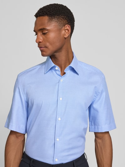 Männermodel trägt Regular Fit Businesshemd aus reiner Baumwolle Modell 'H-JOE-K-SH-C1-262' von BOSS, Optik:Allover-Muster, Kentkragen, durchgehende Knopfleiste, Rückenpasse, Kurzarm, leicht abgerundeter Rumpfabschluss, bügelleicht, Hellblau, feine Struktur, Ganzkörperansicht von vorne.