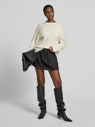 Frauenmodel trägt Regular Fit Pullover aus Alpaka-Mix von black palms in Creme mit Strick-Optik, Rundhalsausschnitt, elastische Abschlüsse, Rückenlänge bei Größe S 60 cm, Ganzkörperansicht von vorne.