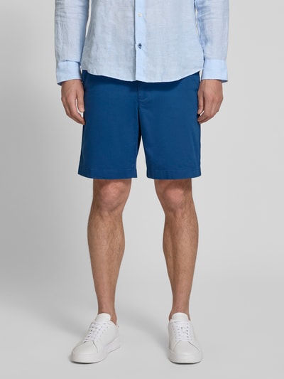 Männermodel trägt Chinoshorts aus Baumwoll-Mix Modell 'DOVER' von Tommy Hilfiger, Optik: Unifarben, Passform: Regular-Fit, Ganzkörperansicht von vorne.