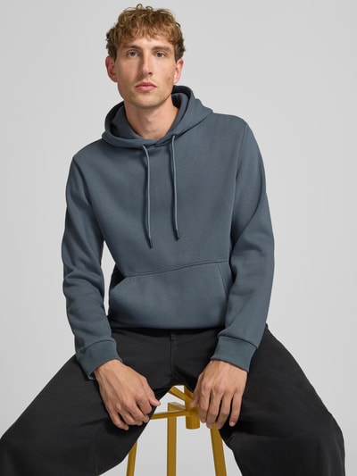 Männermodel trägt Hoodie mit Känguru-Tasche Modell 'BRADLEY' von JACK & JONES in Blau, lockerer Schnitt, Baumwoll-Mix, Nahaufnahme Oberkörper.