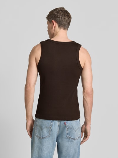 Männermodel trägt Tanktop in Ripp-Optik Modell 'Nathan' von Drykorn aus Reine Baumwolle, Slim-Fit, dunkles Braun, Rückenlänge 62 cm, Ganzkörperansicht Rückansicht.