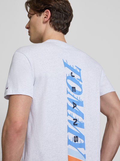 Männermodel trägt Regular Fit T-Shirt aus reiner Baumwolle von Tommy Jeans, unifarben mit Label Print, Jersey-Material, Ganzkörperansicht Rückansicht.