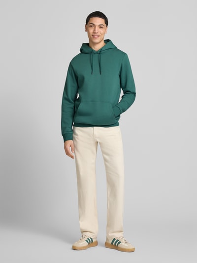 Männermodel trägt Regular Fit Hoodie aus Baumwoll-Mix Modell 'CERES' von Only & Sons, Optik: Unifarben, Label-Stitching-Applikation, Kängurutasche, Kapuze mit Tunnelzug, Langarm, Ärmelabschluss und Rumpfabschluss gerippt, Materialverarbeitung: Sweat, Ganzkörperansicht von vorne.