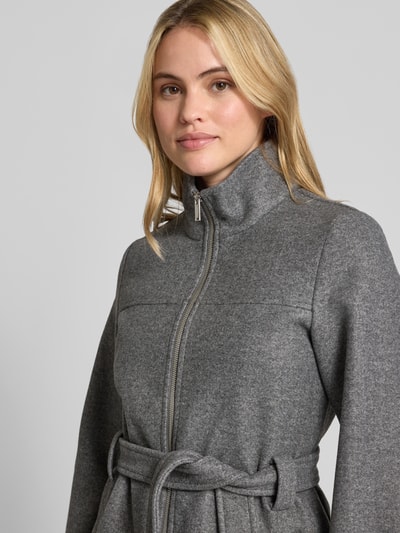 Frauenmodel trägt einen grauen Regular Fit Mantel mit Taillengürtel von VERO MODA, weiche Textur, Nahaufnahme Oberkörper. Damen Teddy- / Webpelzmantel.