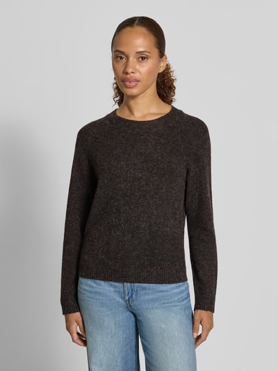Modelka nosi ciemnobrązowy sweter z okrągłym dekoltem Regular Fit model 'DOFFY' od VERO MODA, kolor jednolity, damski sweter, widok całej sylwetki z przodu.
