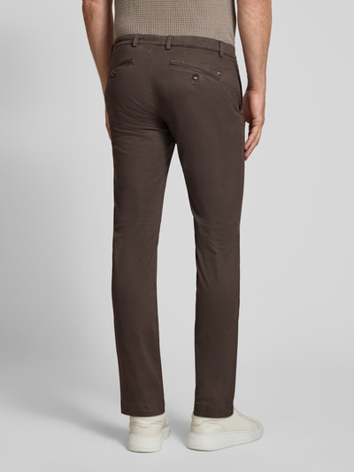 Männermodel trägt Slim Fit Chino aus Baumwoll-Mix von bugatti in Braun mit Gesäßtaschen, Ganzkörperansicht Rückansicht, KI-modifiziertes Bild.