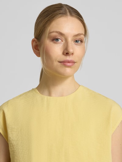 Frauenmodel trägt Bluse mit Rundhalsausschnitt und Kappärmeln von Jake*s Collection in Gelb, sichtbare Struktur, Nahaufnahme Oberkörper.