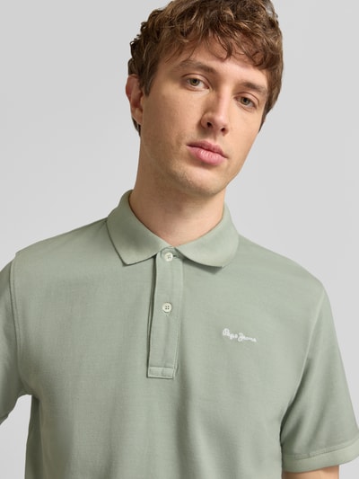 Männermodel trägt Regular Fit Poloshirt aus reiner Baumwolle Modell 'OSCAR' von Pepe Jeans, Optik: Unifarben, Nahaufnahme Oberkörper.