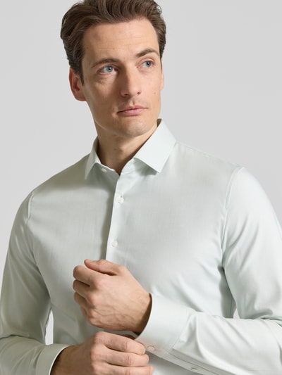Männermodel trägt Super Slim Fit Business-Hemd Modern Kent Uni Twill von OLYMP No. Six, elastischer Baumwoll-Mix, Nahaufnahme Oberkörper.