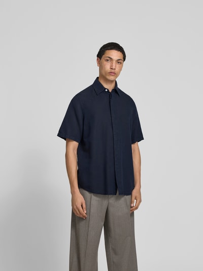 Männermodel trägt Relaxed Fit Leinenhemd mit Kentkragen von Filippa K, dunkelblau, Baumwoll-Leinen-Mix, Kurzärmelig, Ganzkörperansicht von vorne.