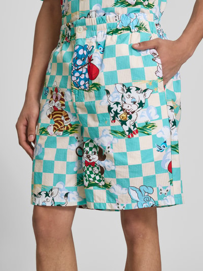 Männermodel trägt Shorts mit Allover-Motiv-Print von Kenzo in turquoise met witte ruit, puur katoen, relaxed fit, elastische band, knoop- en ritssluiting, binnenbeenlengte maat M 41 cm, bandwijdte maat M 18 cm, nahaufnahme bovenbeen
