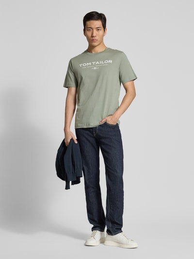 Männermodel trägt Regular Fit T-Shirt aus reiner Baumwolle von Tom Tailor, Optik: Unifarben, Label-Print, Rundhals, Ganzkörperansicht von vorne.