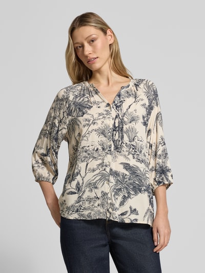 Frauenmodel trägt Relaxed Fit Bluse aus Viskose Modell 'CARLI' von Soyaconcept, cremefarben mit dunkelblauem Allover-Look, V-Ausschnitt, Ganzkörperansicht von vorne.