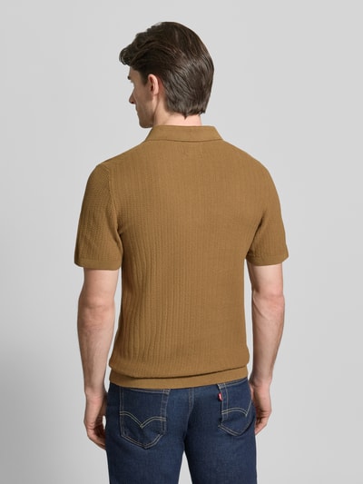 Männermodel trägt Poloshirt mit kurzem Reißverschluss und Polokragen von MCNEAL aus Bio-Baumwolle in Braun, Strukturmuster, Ganzkörperansicht Rückansicht. Rückenlänge bei Größe M: 69 cm, Ärmellänge bei Größe M: 25 cm, Body Fit, Gerippte Abschlüsse.