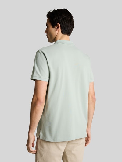 Männermodel trägt Regular Fit Poloshirt aus reiner Baumwolle von Tom Tailor, Optik: Unifarben, Materialverarbeitung: Piqué, Ganzkörperansicht Rückansicht.