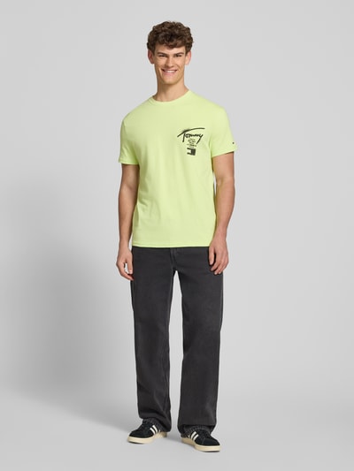 Męski model nosi Regular Fit T-Shirt aus reiner Baumwolle von Tommy Jeans, kolor jednolity, krój regular fit, bawełna, napis z logo, okrągły dekolt, krótki rękaw, jersey, widok całej sylwetki z przodu.
